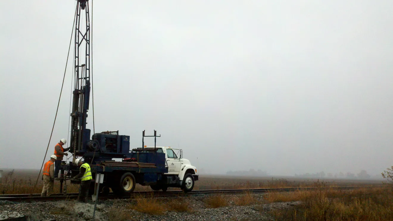 A drilling crew collecting subsurface samples — the Phase 2 work that confirms a property is a 'facility' and documents existing contamination for a Baseline Environmental Assessment