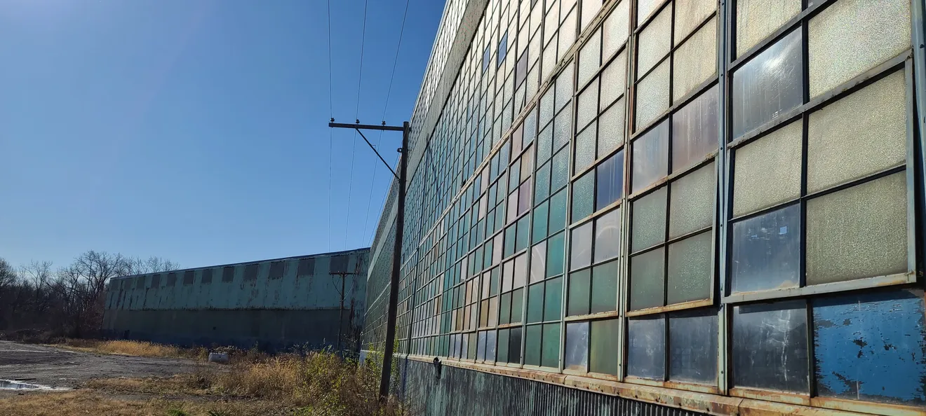 The long window wall of a former manufacturing plant — the kind of redevelopment site that generates soil needing classification